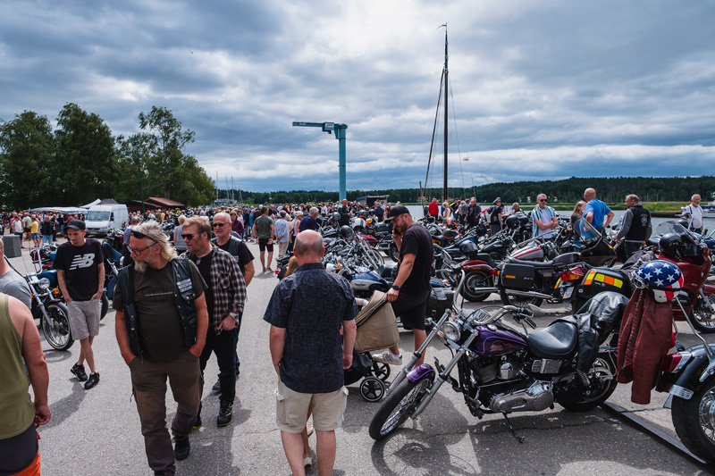 Folk strosar runt och tittar på motorcyklarna som är utställda i Nyköpings småbåtshamn.